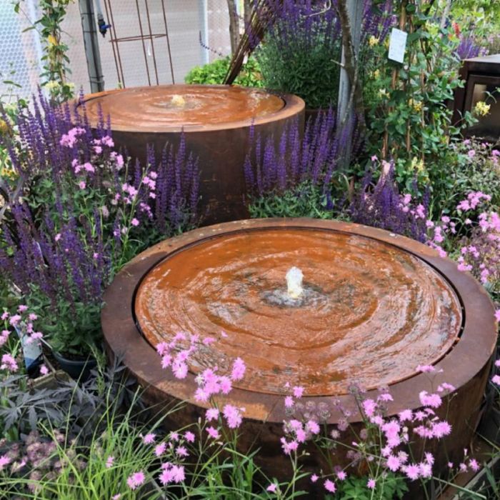 Laguna Bowl Fountain featured among vibrant flowers, showcasing a beautiful water flow in a garden setting.